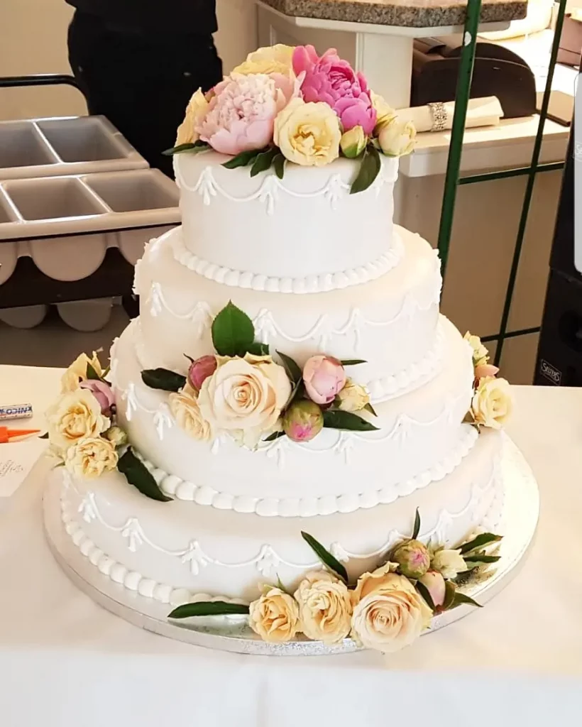 4-stöckige Hochzeitstorte in weißem Fondant mit echten Rosen